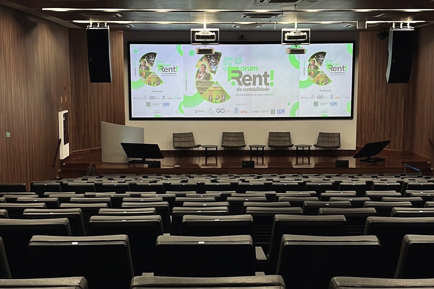 Auditório TOTVS montado para o Fórum Rent, com o telão do evento e a plateia