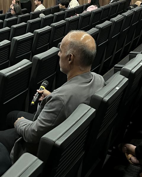 Participante fazendo pergunta ao microfone