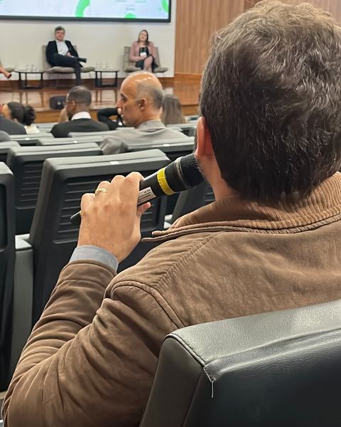 Participante ao microfone no meio da plateia