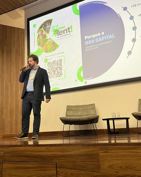 Palestrante ao microfone na apresentação da GO2 Capital