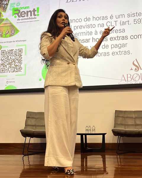 Palestrante explicando ao microfone no palco